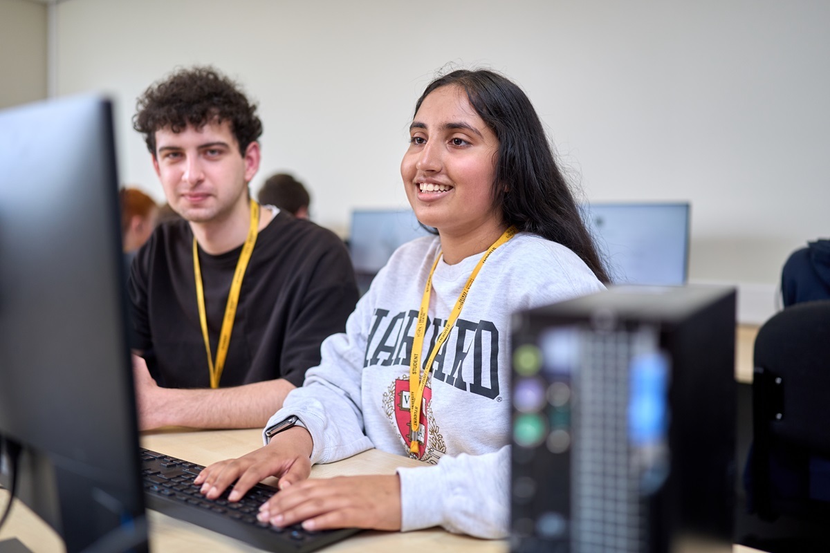 Two Computer Games Design students looking at a computer screen