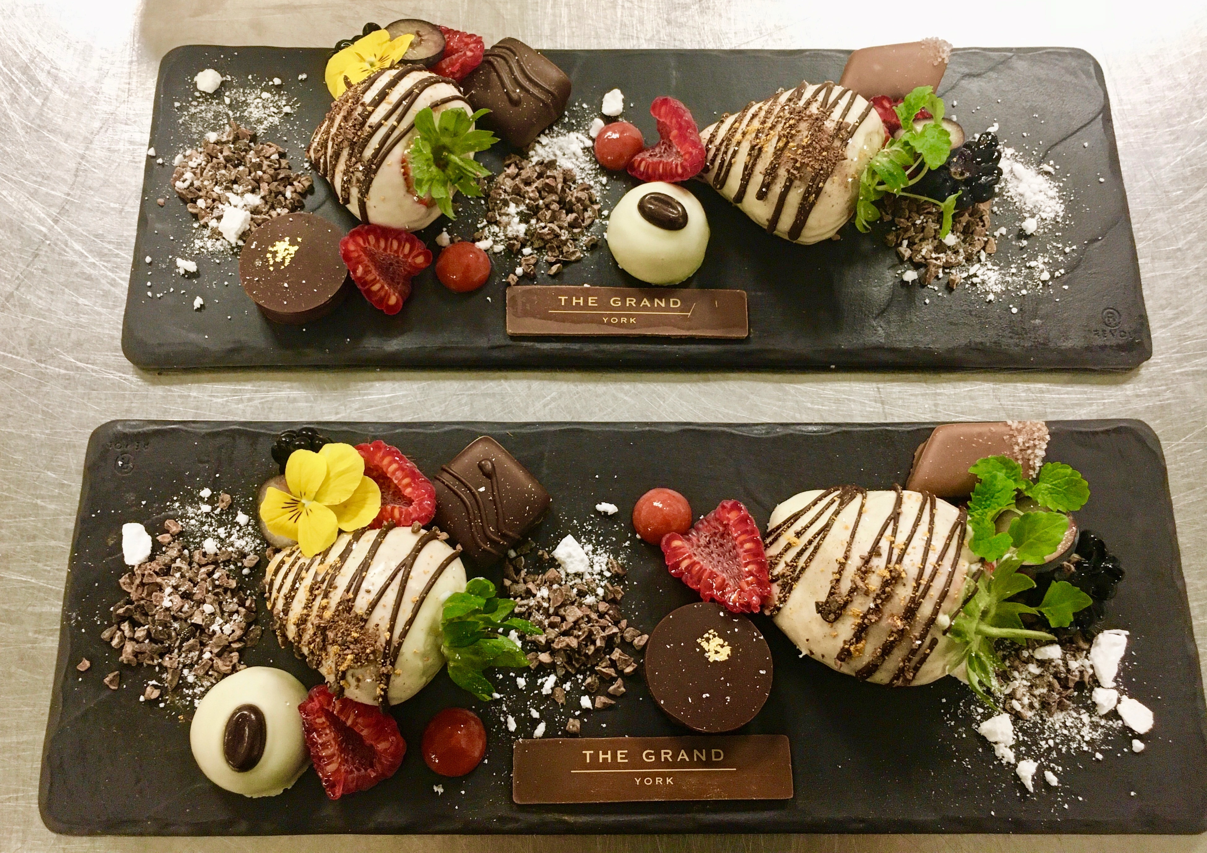 Two platters for The Grand hotel of strawberries covered in milk chocolate individual dark milk and white chocolates garnished with mint leaves and assorted fruit