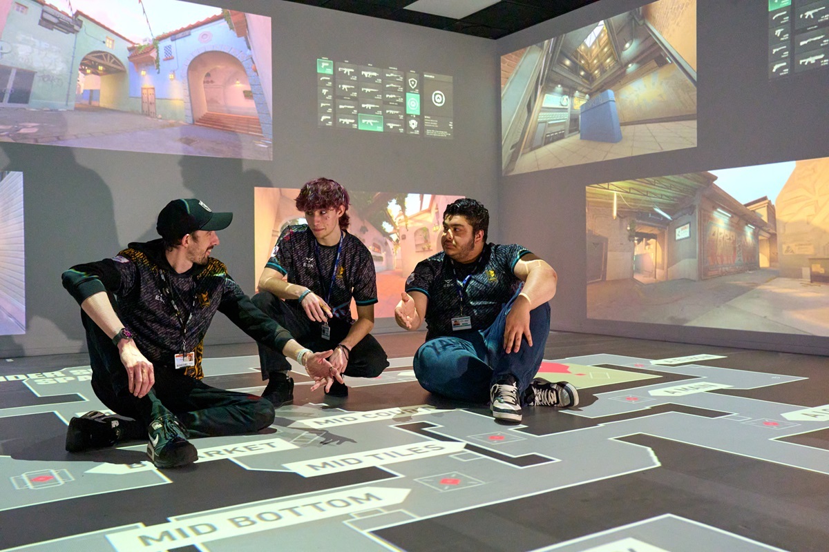 Two students and theit tutor chat about tactics on an interactive map Esports