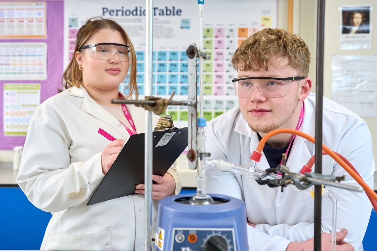 Two students conduct a practical Science experiment Access
