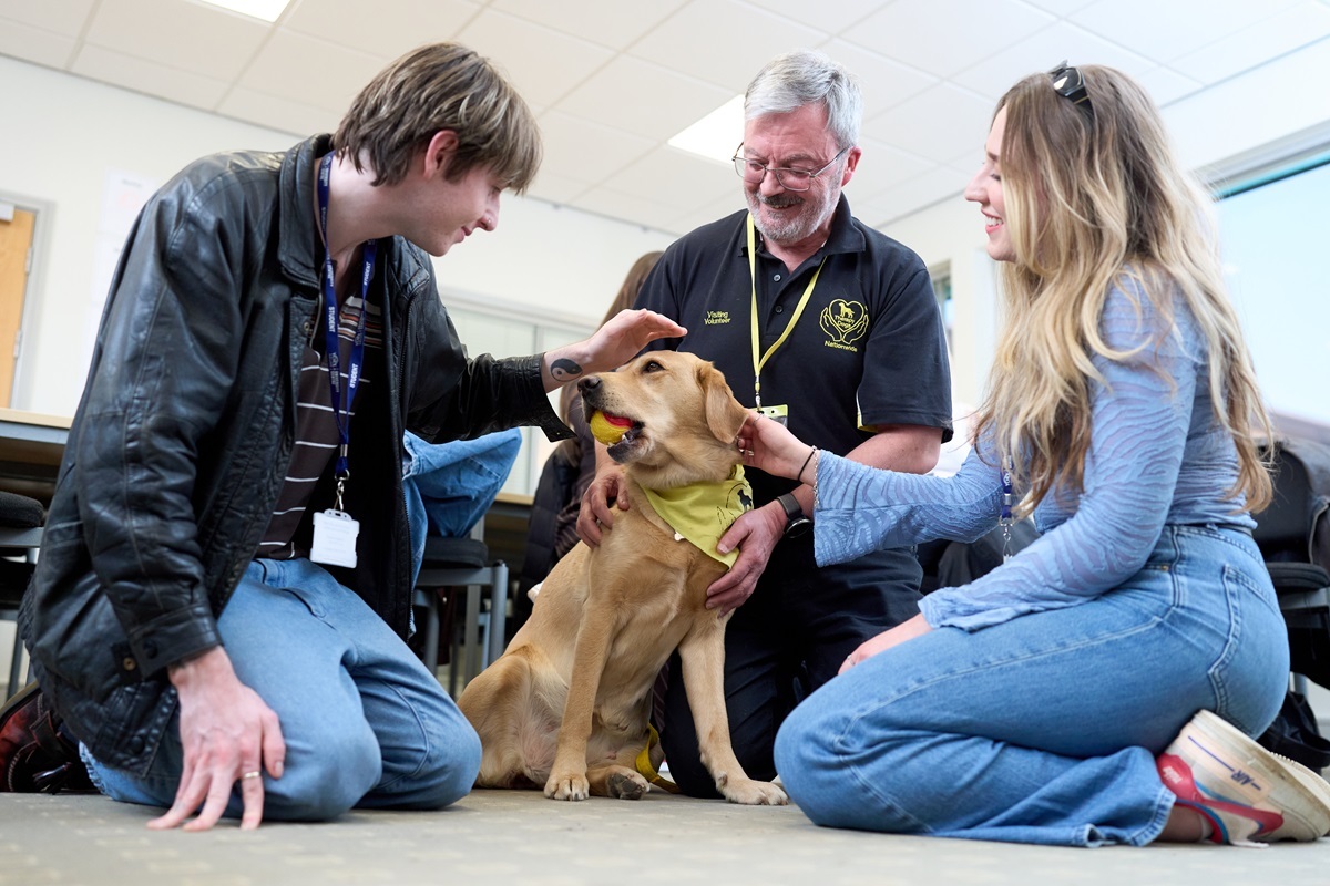 Two students interact with a therpay dog Counselling