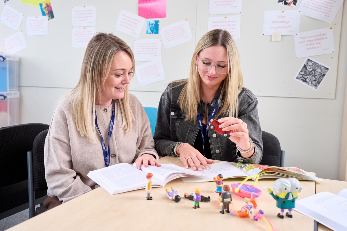 Two students read their notes and study some toys Childrens Development