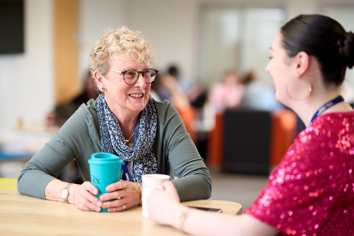 Two students smile and chat Supporting You