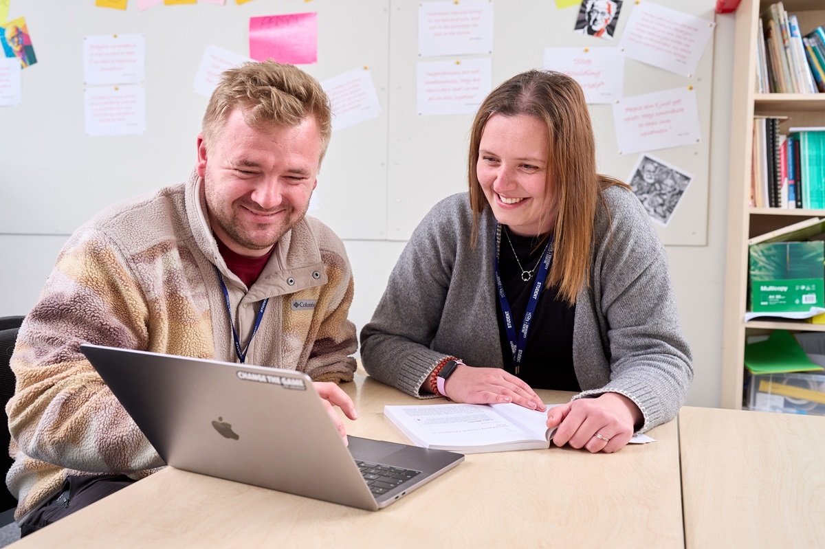 Two students smile at a laptop Childrens Development