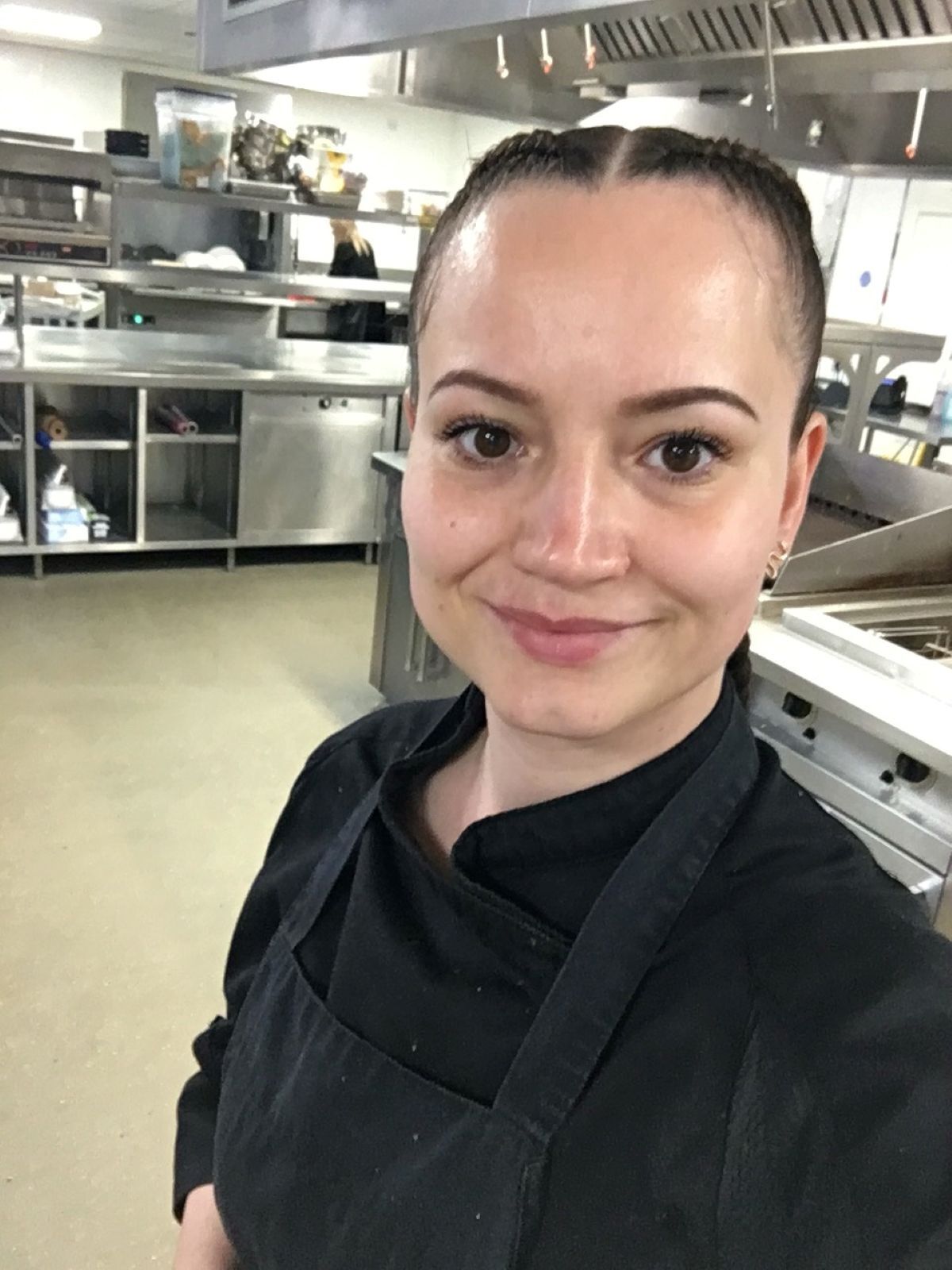 Valentina Zarins selfie picture in front of stainless steel kitchen equipment