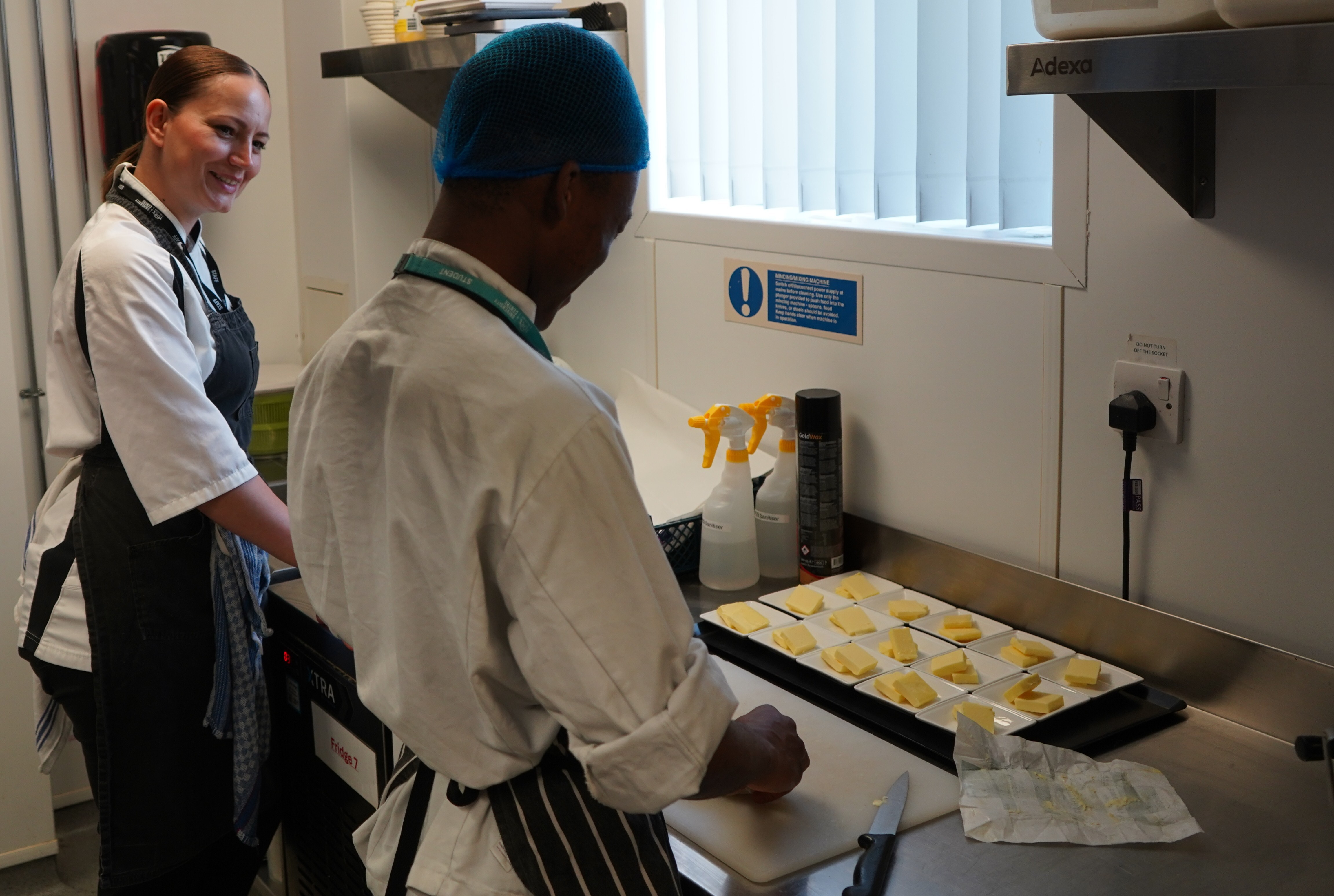 Valentina Zarins works alongside a male student preparing butter side dishes for a Fish Chip service in York Colleges The Cookery kitchen