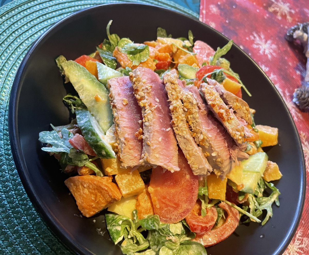Veg and fruit salad with rare cooked meat on top