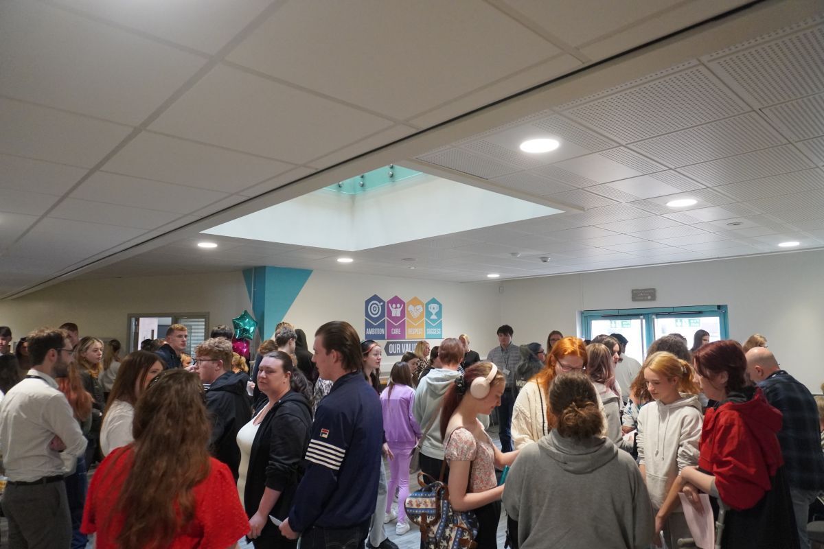York College students and family members talking to tutors and other college members of staff in front of the GCSE results desks