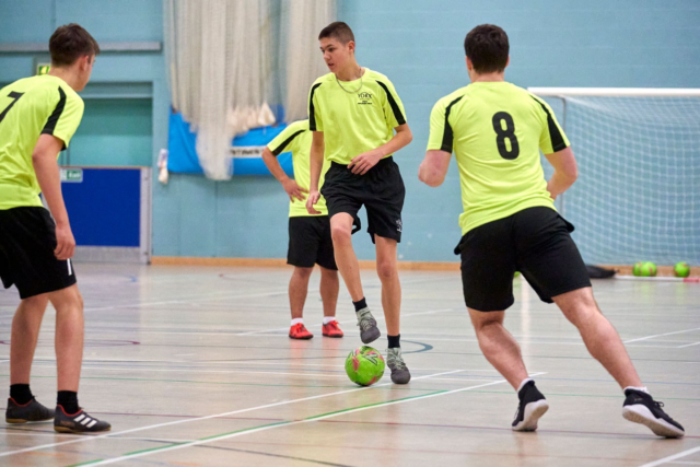 Students in the sports hall playing futsal