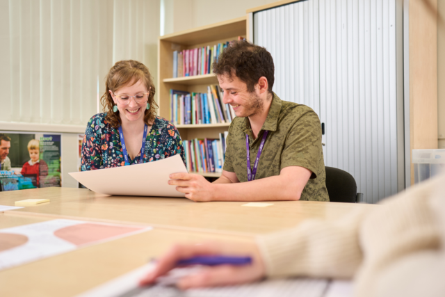 Tutor and student look at work Teacher Training