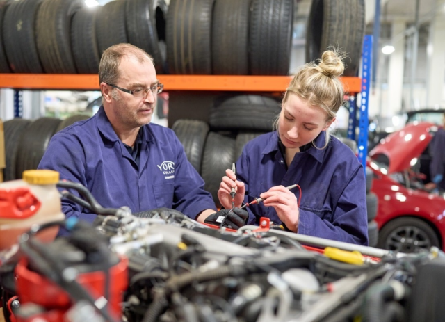 Motor Vehicle tutor observing a student testing the car electrics