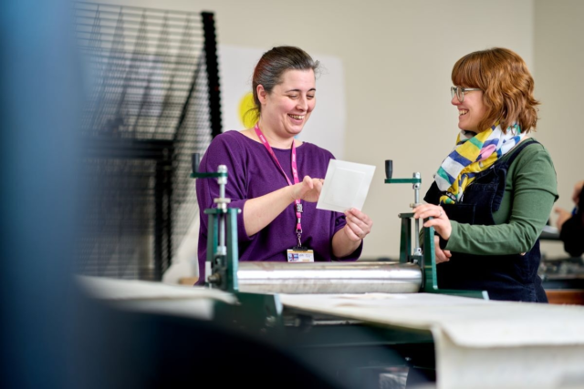 A student and a tutor look at a printing design Graphics