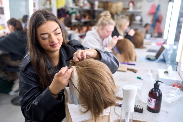 A student works on a wig Media Make up