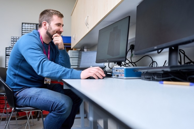 An Engineering student creates designs on a laptop
