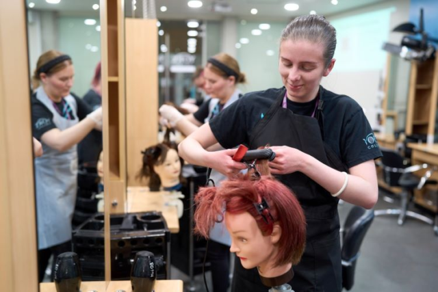 A student curls some hair