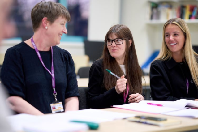 A group of students smile and chat in Spanish