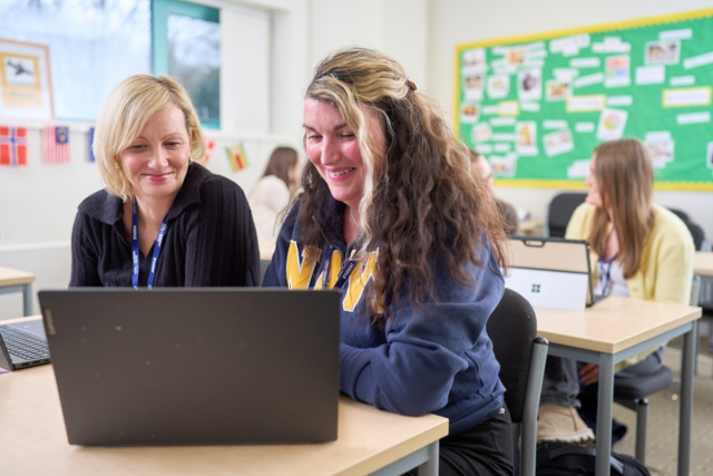 Two students work on a laptop and smile CIPD