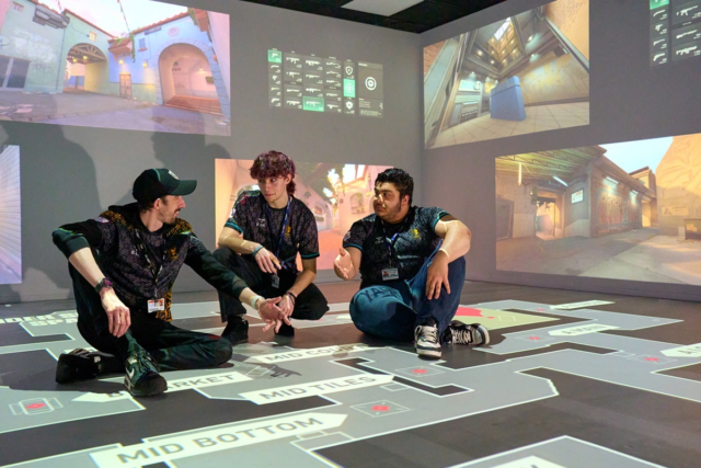 Two students and theit tutor chat about tactics on an interactive map Esports