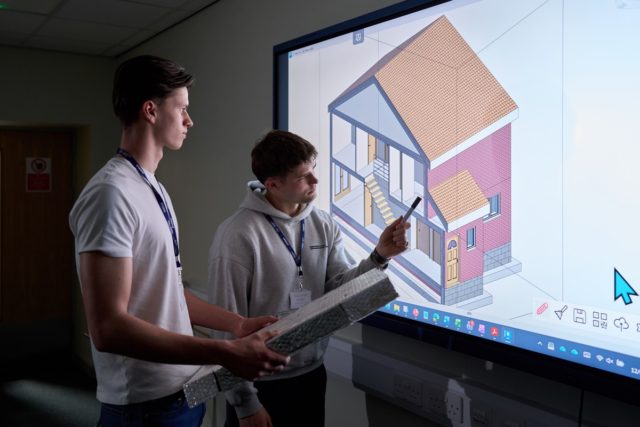 Two students look at an architectural drawing Construction
