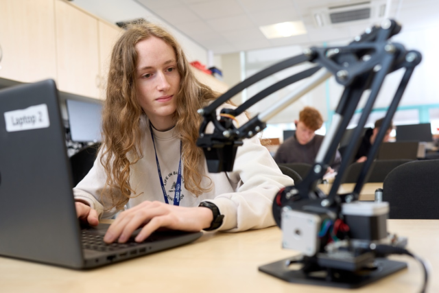 A student controls a robotic arm Engineering