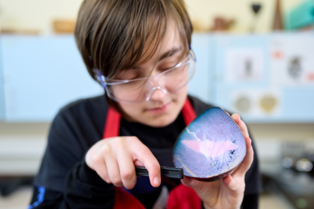 A student files a piece of rock 3 D