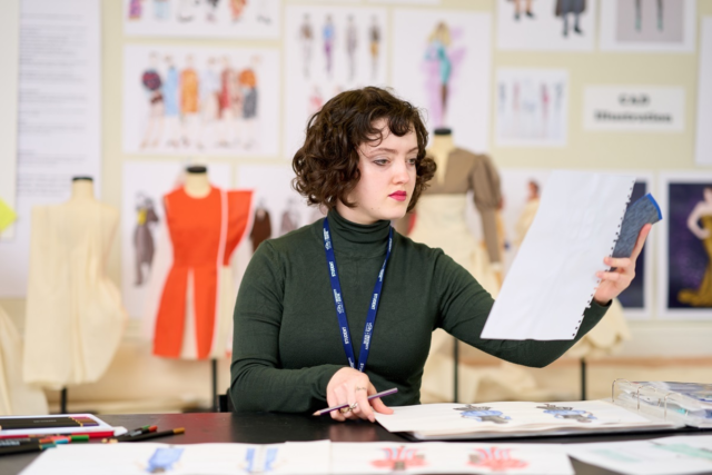 A student holds up a design Fashion