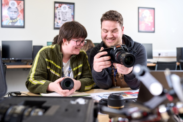Two students set up a camera and compare lenses Film