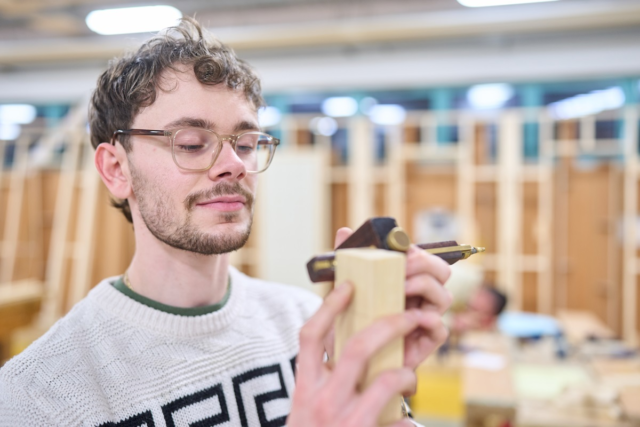 A student measures some wood Joinery