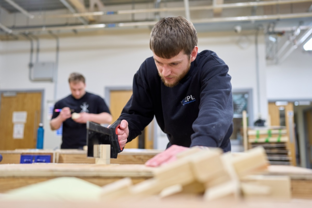 A student saws wood Joinery