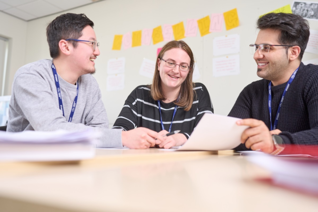 Three students smile at eachother GCSE English