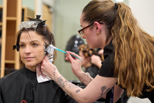A student colours a clients hair Hairdressing