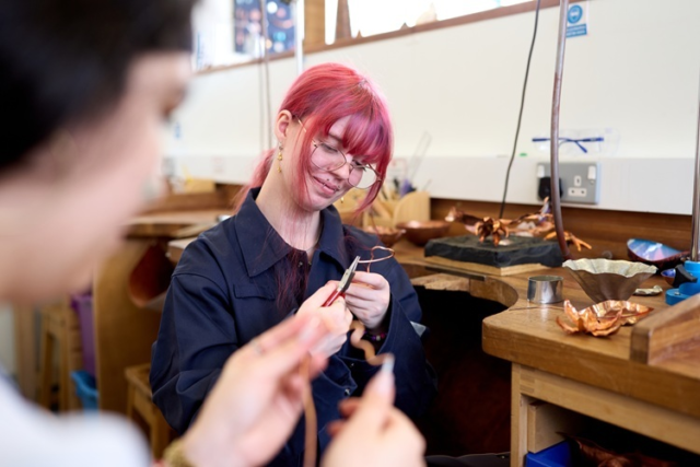 A student bends some copper Jewellery