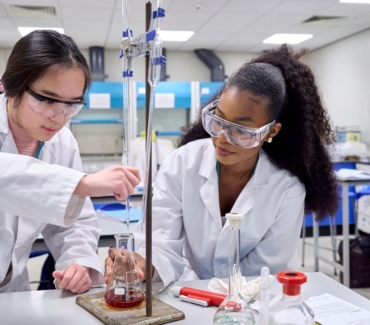 2 science students carrying out a practical experiment in a lab