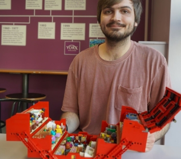 Joe Bailey poses behind his opened Workshop in a Toolbox Lego set
