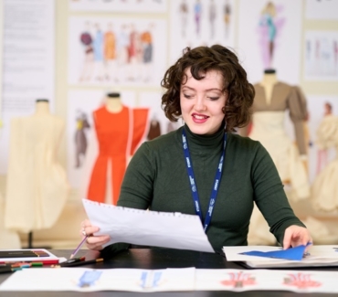 A student holds some work up to examine Fashion