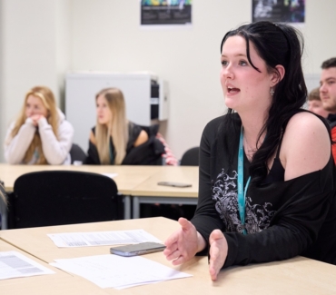 A vocational Uniformed Services student is speaking in a classroom discussion