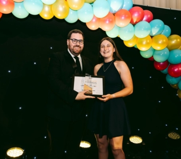 Georgina Richardson receives the Principals Award at the York College REACH Awards from Principal Ken Merry in front of a balloon arch