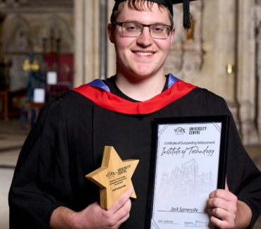 Jack Somerville holds his award and certificate at the York College University Centre Graduation Ceremony in York Minster