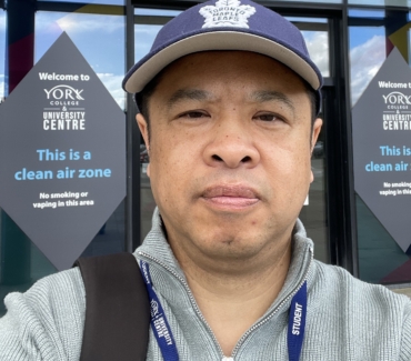 Mao Chen selfie picture in front of York Colleges main entrance