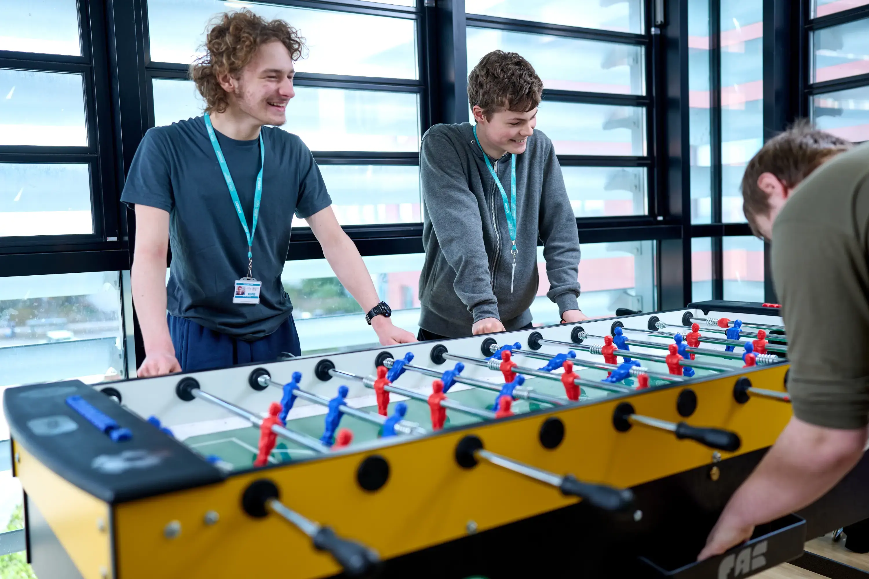 Three students playing table football